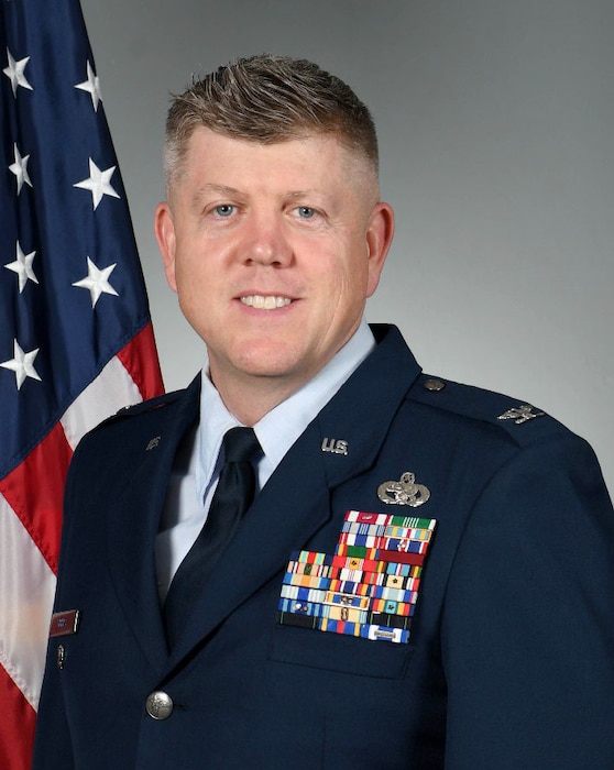 a man in front of a U.S. flag