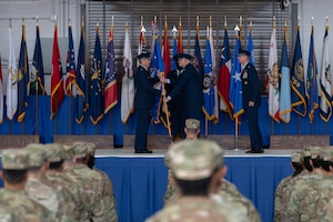Lt. Gen. Michael Conley, commander of Air Force Special Operations Command, hands the 1st Special Operations Wing guidon to Col. Mark Hamilton during a change of command ceremony at Hurlburt Field, Florida, Oct. 6, 2025.