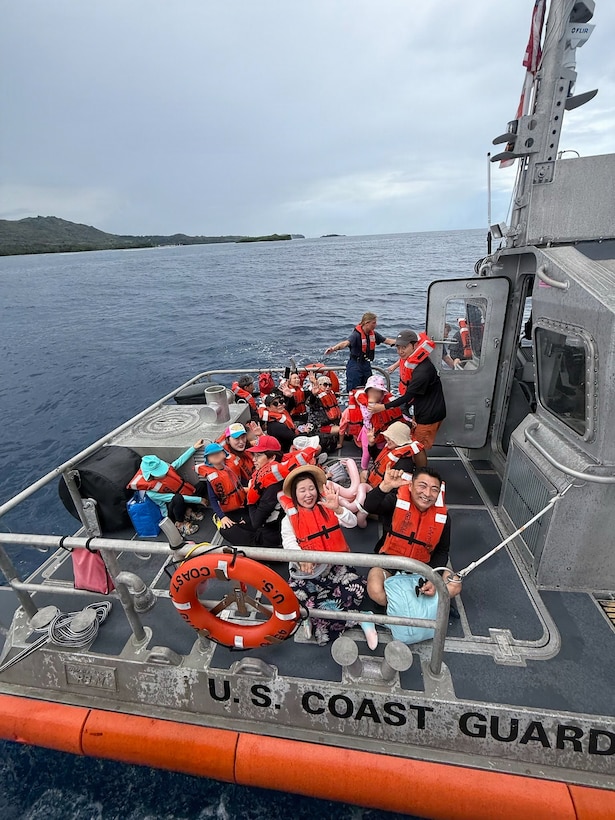Passengers rescued from a disabled vessel gather on the deck of a Coast Guard 45-foot Response Boat-Medium from Station Apra Harbor off Agat, Guam, Oct. 10, 2025. Coast Guard and Guam Fire Department crews responded to a report of a 45-foot passenger vessel with smoke coming from its engines. (U.S. Coast Guard photo, courtesy Station Apra Harbor)
