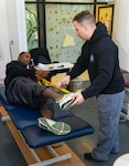 251017-N-FB730-1002 CAMP LEJEUNE. (October 17, 2025) Hospital Corpsman second class Cory Grimm assist a patient with stretches in the physical therapy clinic at Naval Medical Center Camp Lejeune on October 17, 2025. (U.S. Navy photo by Mass Communications Specialist 2nd Class Justin Woods)