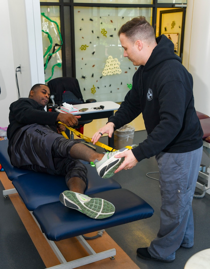 251017-N-FB730-1002 CAMP LEJEUNE. (October 17, 2025) Hospital Corpsman second class Cory Grimm assist a patient with stretches in the physical therapy clinic at Naval Medical Center Camp Lejeune on October 17, 2025. (U.S. Navy photo by Mass Communications Specialist 2nd Class Justin Woods)