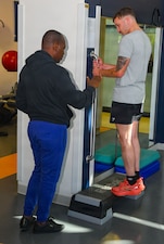 251017-N-FB730-1005 CAMP LEJEUNE. (October 17, 2025) Hospitalman Lamech Kabonge, a physical therapy technician student, assists a patient with stretches in the physical therapy clinic at Naval Medical Center Camp Lejeune on October 17, 2025. (U.S. Navy photo by Mass Communications Specialist second class Justin Woods)