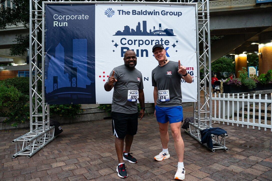 U.S. Army Corps of Engineers Jacksonville District runners pose in from of the racing banner.