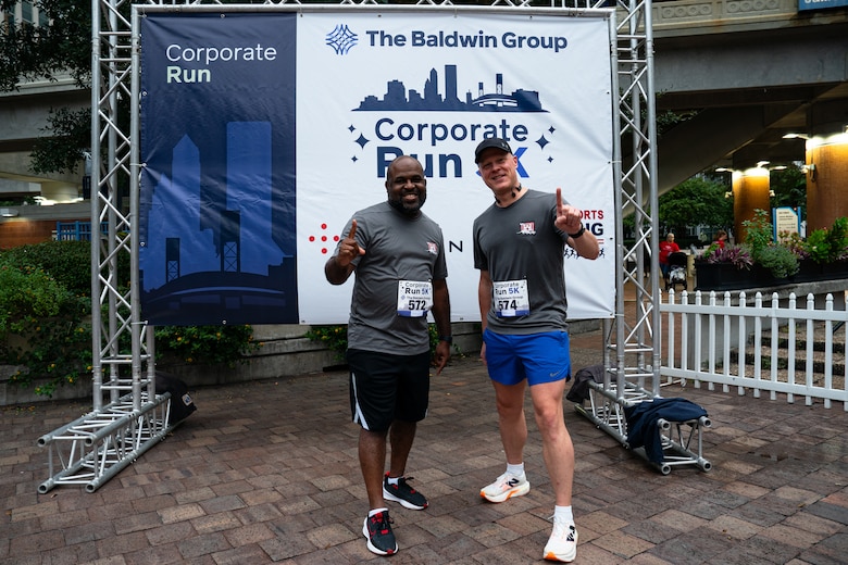 U.S. Army Corps of Engineers Jacksonville District runners pose in from of the racing banner.