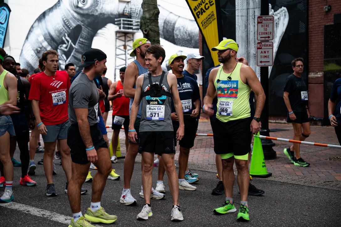Seed runners talking and shaking out racing jitters at the start line.