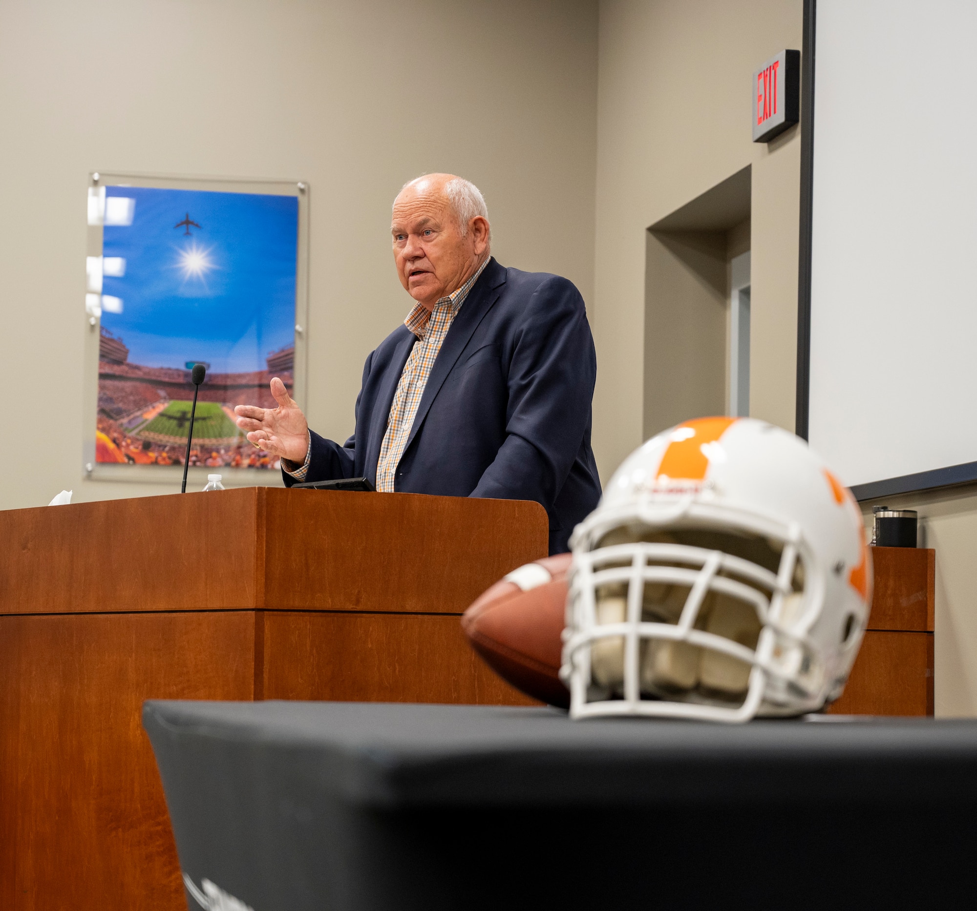 Former University of Tennessee Knoxville Athletic Director Phillip Fulmer speaks in the background, a Tennessee helmet in the foreground.