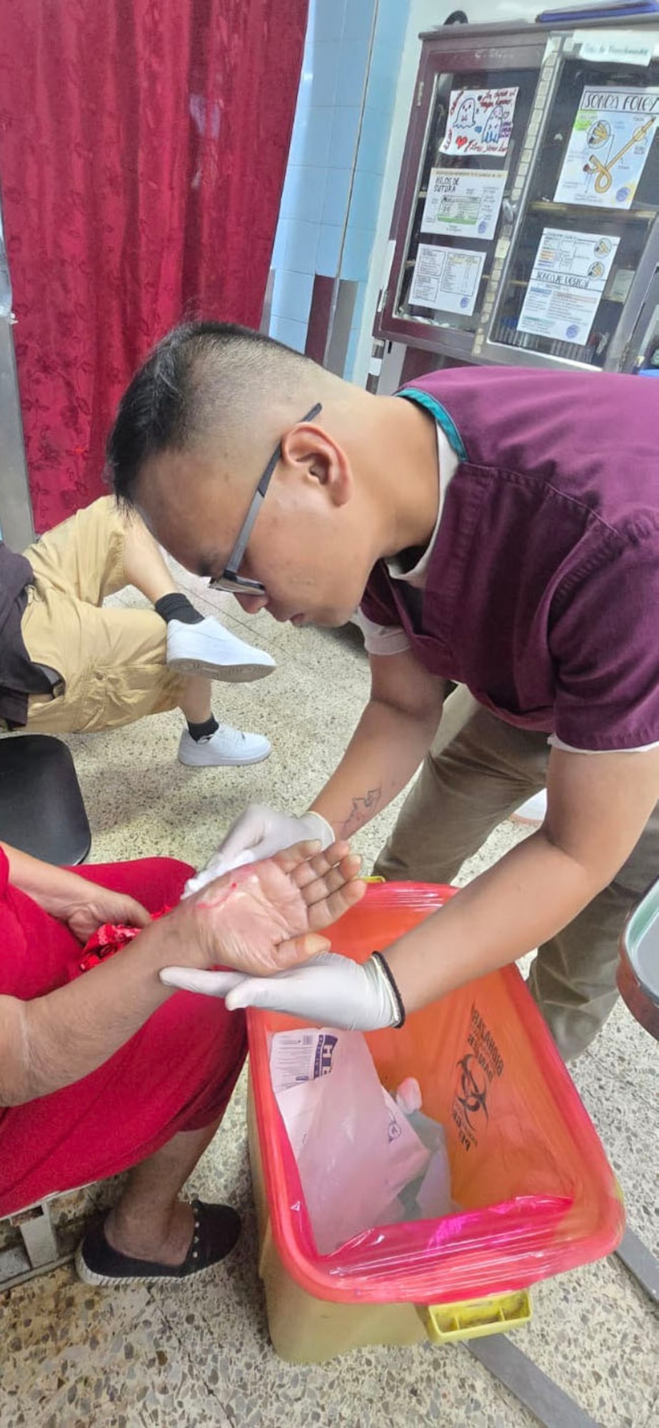 A man holds a woman's hand while applying bandages.