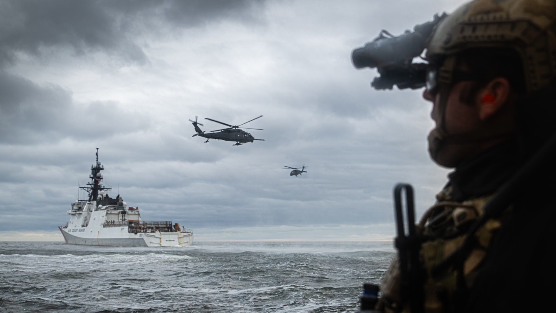 A member of the Navy Seals converges with Coast Guard Cutter Waesche (WMSL 751) and Air force HH-60 Pave Hawk helicopters during Arctic Edge 2025 near Nome, Alaska, Aug. 10, 2025. AE25 is a North American Aerospace Defense Command (NORAD) and U.S. Northern Command-led homeland defense exercise designed to improve readiness, demonstrate capabilities, and enhance Joint and Allied Force interoperability in the Arctic. (U.S. Coast Guard photo by Petty Officer 3rd Class Cameron Snell)