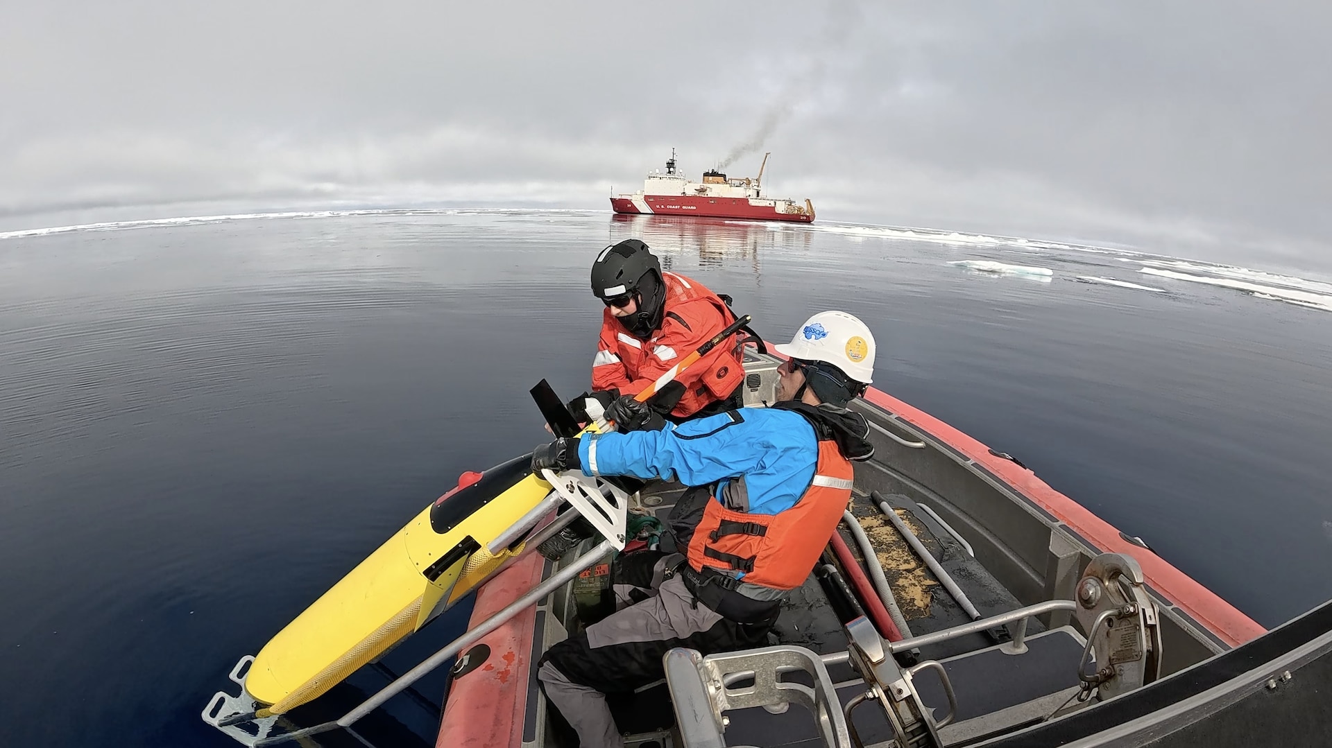 U.S. Coast Guard Petty Officer 2nd Class Jared Vannoy (right) and Justin Burnett, an Arctic Mobile Observing System research engineer, pull a Seaglider Undersea Vehicle aboard a Coast Guard Cutter Healy (WAGB 20) small boat while operating in the Arctic Ocean, Aug. 5, 2025. The dense batteries in the seaglider are mounted on a rail to allow adjustments to its center of gravity, creating the ability to steer. (U.S. Coast Guard courtesy photo by Petty Officer 2nd Class Zack Ledoux)