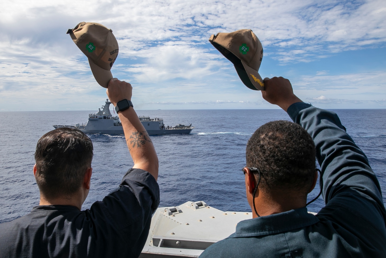 Quartermaster Seaman Damien Dobbs, left, and Cmdr. Paul Richardson, commanding officer of Arleigh Burke-class guided-missile destroyer USS Fitzgerald (DDG 62), wave to the crew of the Philippine Navy Jose Rizal-class guided-missile frigate BRP Jose Rizal (FF-150) while conducting passing exercise during a maritime cooperative activity (MCA) in the Philippines’ exclusive economic zone (EEZ), Oct. 31, 2025.