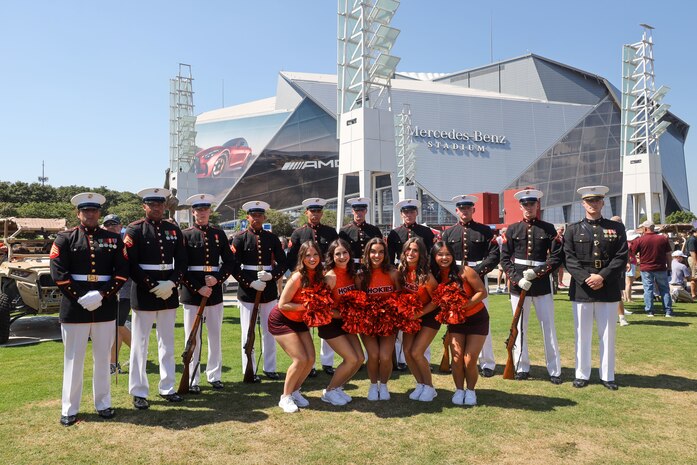 U.S. Marines with the United States Marine Corps Silent Drill Platoon pose for a photo with cheerleaders from Virginia Tech following their performance at the College Football Aflac Kickoff show during Marine Week Atlanta in Atlanta, Ga., Aug. 31, 2025. The year 2025 marks the 250th anniversary of the United States Marine Corps, a milestone that highlights the legacy, transformation and enduring spirit of the Corps since 1775. Throughout the year, Marines across the globe will commemorate this anniversary by honoring the service and sacrifice of those who served before them and by remaining faithful to the motto Semper Fidelis. (U.S. Marine Corps photo by Cpl. Christopher Prelle)