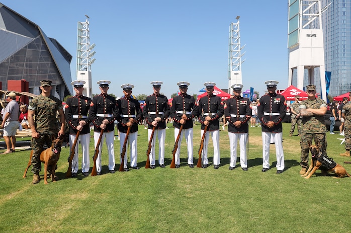 U.S. Marines with the United States Marine Corps Silent Drill Platoon pose for a photo with the military working dog handlers of Marine Corps Police Department Albany following their performance the College Football Aflac Kickoff show during Marine Week Atlanta in Atlanta, Ga., Aug. 31, 2025.The year 2025 marks the 250th anniversary of the United States Marine Corps, a milestone that highlights the legacy, transformation and enduring spirit of the Corps since 1775. Throughout the year, Marines across the globe will commemorate this anniversary by honoring the service and sacrifice of those who served before them and by remaining faithful to the motto Semper Fidelis. (U.S. Marine Corps photo by Cpl. Christopher Prelle)