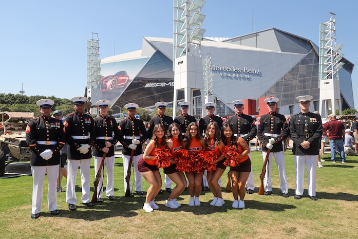 U.S. Marines with the United States Marine Corps Silent Drill Platoon pose for a photo with cheerleaders from Virginia Tech following their performance at the College Football Aflac Kickoff show during Marine Week Atlanta in Atlanta, Ga., Aug. 31, 2025. The year 2025 marks the 250th anniversary of the United States Marine Corps, a milestone that highlights the legacy, transformation and enduring spirit of the Corps since 1775. Throughout the year, Marines across the globe will commemorate this anniversary by honoring the service and sacrifice of those who served before them and by remaining faithful to the motto Semper Fidelis. (U.S. Marine Corps photo by Cpl. Christopher Prelle)