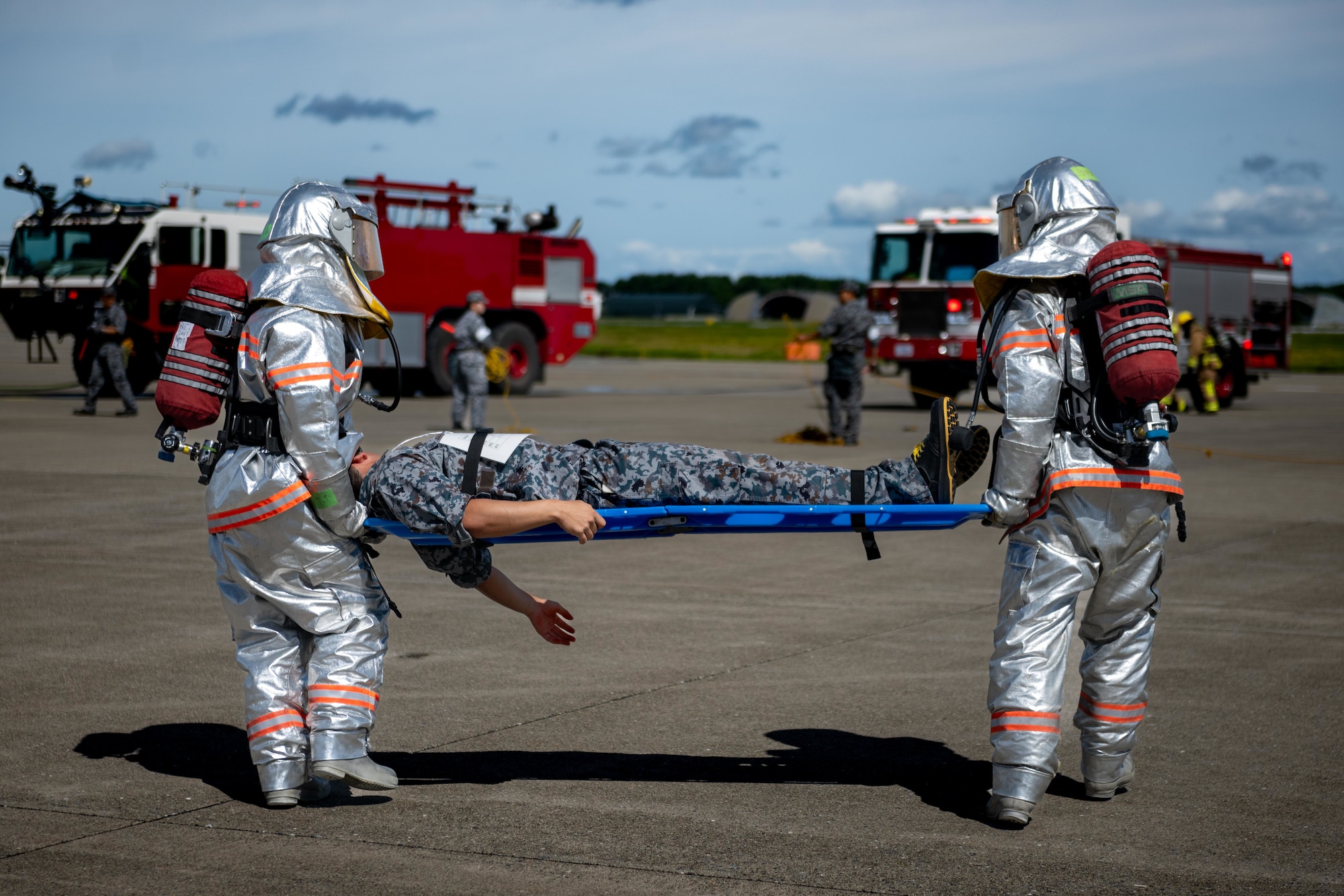Japan Air Self-Defense Force Airmen assigned to the 3rd Air Wing evacuate a simulated patient during an aircraft mass casualty exercise.