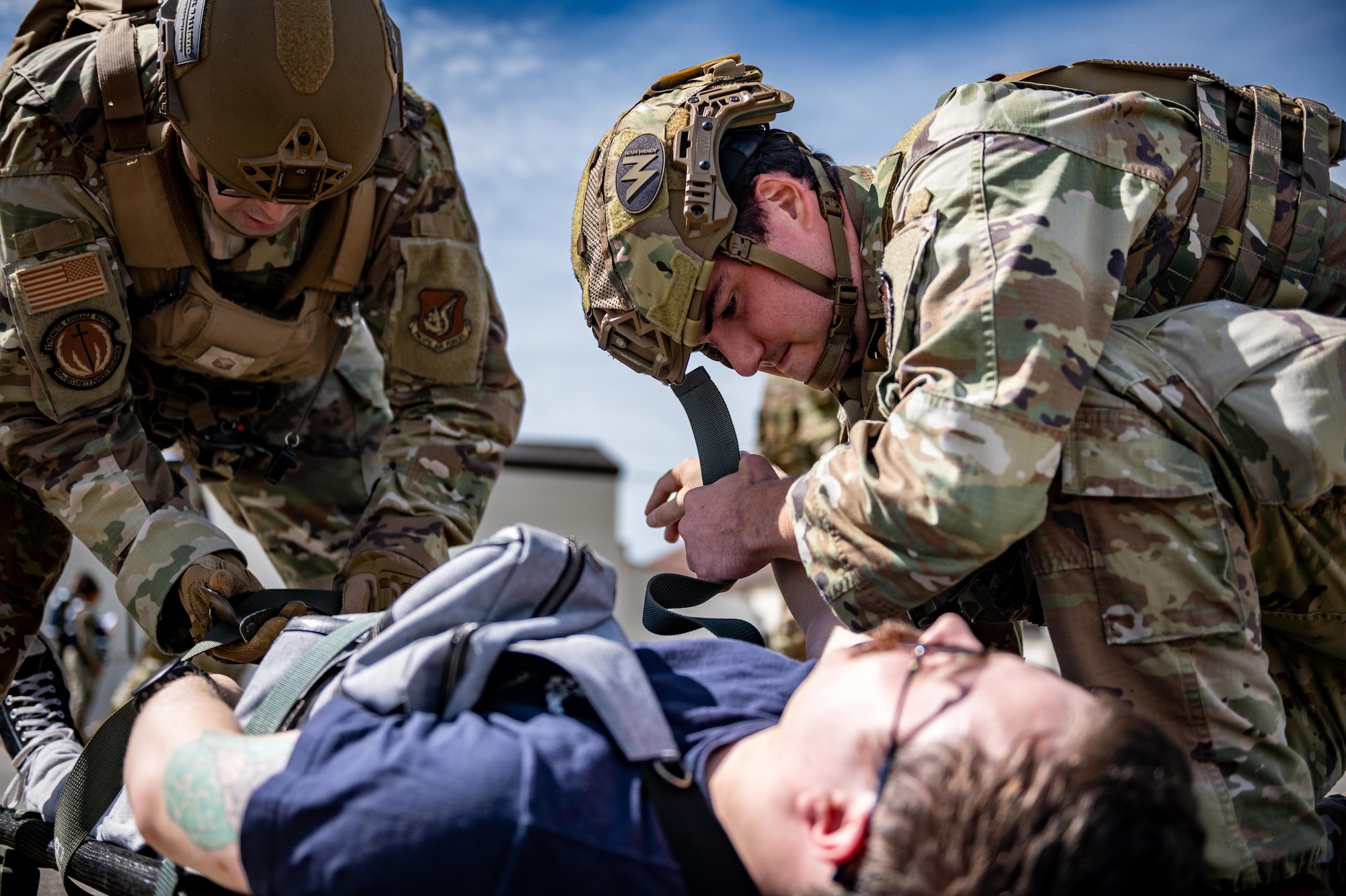 U.S. Air Force Airmen assigned to the 35th Security Forces Squadron strap a simulated patient to a stretcher during an aircraft mass casualty exercise.