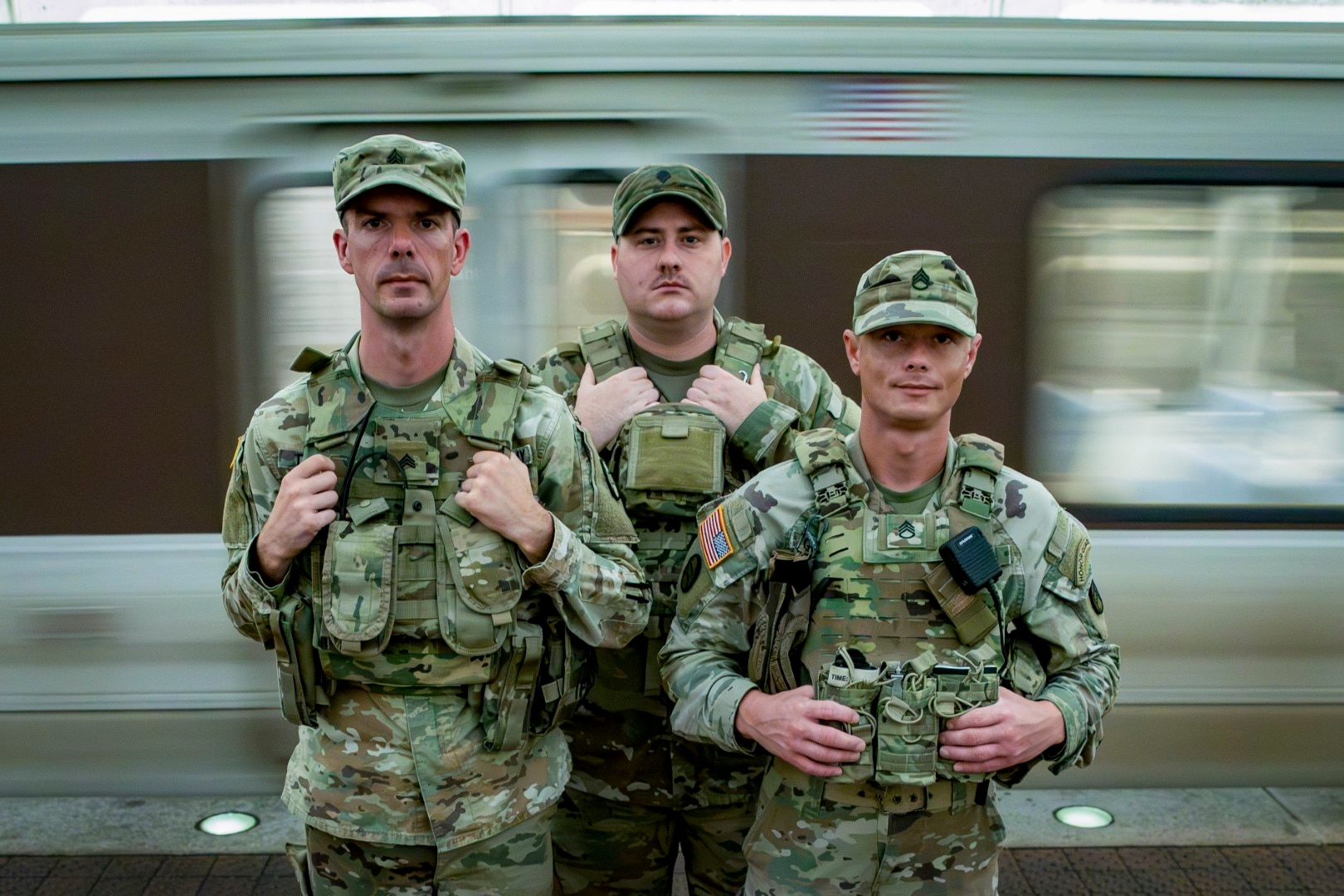 (From left) U.S. Army Sgt. Russell Dozier, Spc. Nichalos Garrison, and Staff Sgt. Zachery Graham all assigned to the 4-118th Infantry Regiment, South Carolina Army National Guard, stand together during a patrol of a Washington Metro station in Washington, D.C. Aug. 23, 2025.