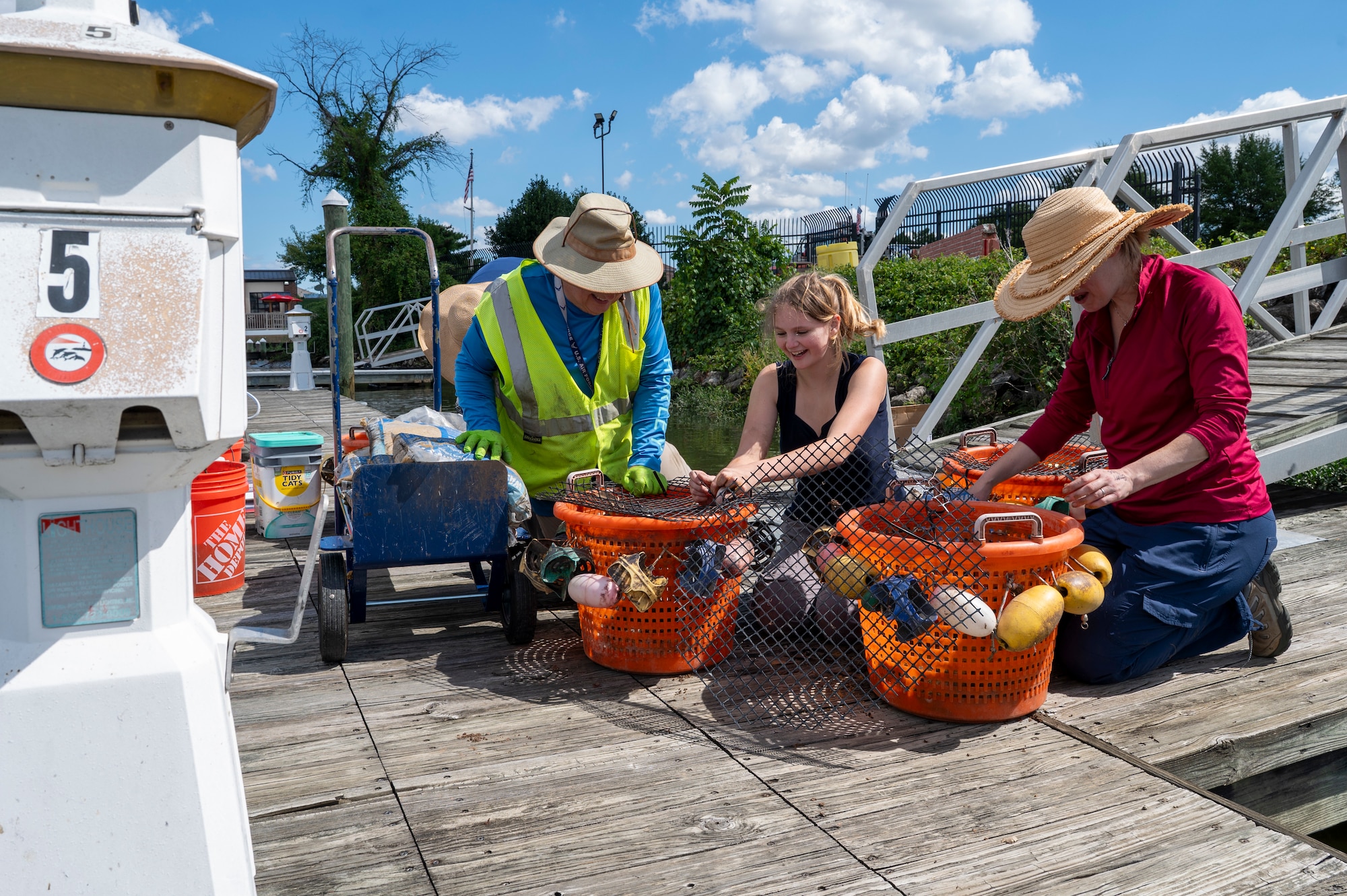 From left, Michael Hooks, an environmental engineer with the U.S. Air Force’s 11th Civil Engineer Squadron, Emma Schuldt, a volunteer, and Jennifer McDonnell, installation management flight chief with the 11th CES, attach a protective cover to buckets of young mussels to release into the Potomac River at Joint Base Anacostia-Bolling, Washington, D.C., Aug. 22, 2025. The covers protect the young mussels from predators while the mussels reach maturity. The 11th CES partnered with the National Fish and Wildlife Foundation and the Anacostia Watershed Society to release the mussels, which help clean the water by filtering excess nutrient pollutants. Located at the confluence of the Potomac and Anacostia Rivers, which empty into the Chesapeake Bay watershed, JBAB provides an ideal location for the release initiative. (U.S. Air Force photo by Hayden Hallman)
