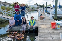 Members of the U.S. Air Force’s 11th Civil Engineer Squadron gather for a group photo next to the young mussels that they released into the Potomac River at Joint Base Anacostia-Bolling, Washington, D.C., Aug. 22, 2025. The 11th CES partnered with the National Fish and Wildlife Foundation and the Anacostia Watershed Society to release the mussels, which help clean the water by filtering excess nutrient pollutants. Located at the confluence of the Potomac and Anacostia Rivers, which empty into the Chesapeake Bay watershed, JBAB provides an ideal location for the release initiative. More than 1,000 young mussels were released during the project. (U.S. Air Force photo by Hayden Hallman)