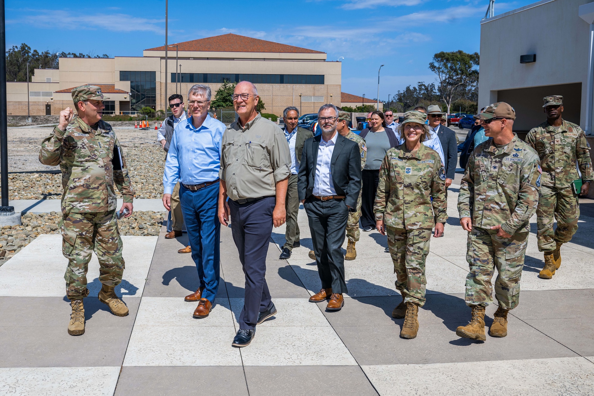 A group of people walk together outside a building.