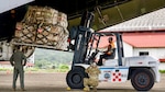 A forklift operator transports a palletized load from the C-5’s rear cargo ramp while ground crews signal in Panama City, Panama, Aug. 30, 2025. The shipment, more than 167,000 pounds packed in four 40-foot containers totaling over 5,000 boxes, was consigned to Fundación Castillo Del Rey, a Panamanian non-governmental organization, for nationwide distribution. (U.S. Air Force photo by Capt. Jymil Licorish)