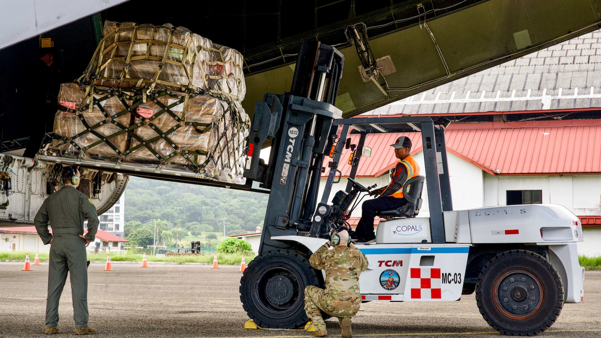 A forklift operator transports a palletized load from the C-5’s rear cargo ramp.