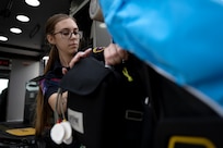 EMS worker repacks equipment inside the van after an inspection.