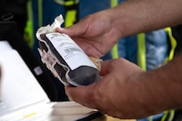 a pair of hands holding a blood bag.