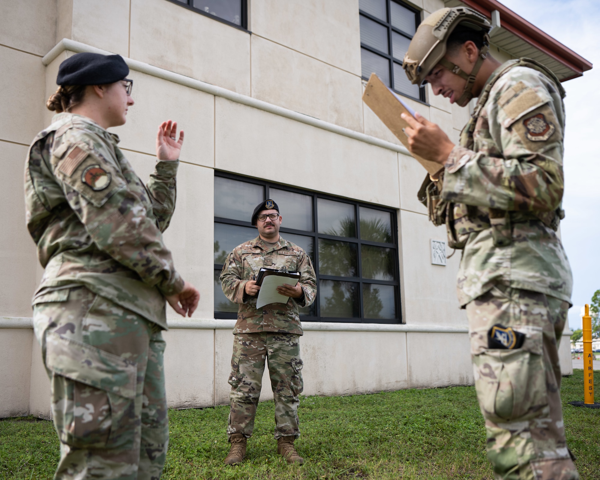U.S. Air Force Staff Sgts. Dakotah Smith, center, and Cierra Felix, left, both evaluators with the 6th Security Forces Squadron, assess Airman 1st Class Jaylaun Hardy while he conducts security procedures at MacDill Air Force Base, Florida, Aug. 26, 2025.