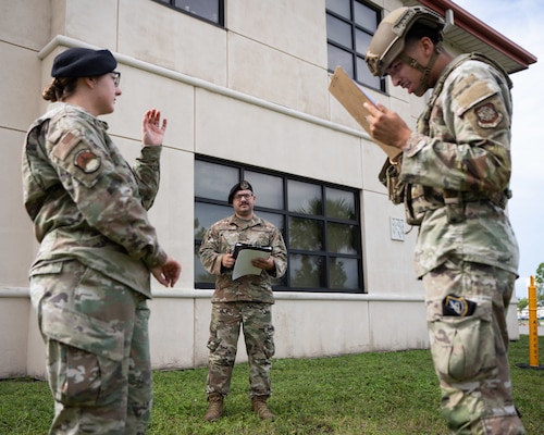 U.S. Air Force Staff Sgts. Dakotah Smith, center, and Cierra Felix, left, both evaluators with the 6th Security Forces Squadron, assess Airman 1st Class Jaylaun Hardy while he conducts security procedures at MacDill Air Force Base, Florida, Aug. 26, 2025.