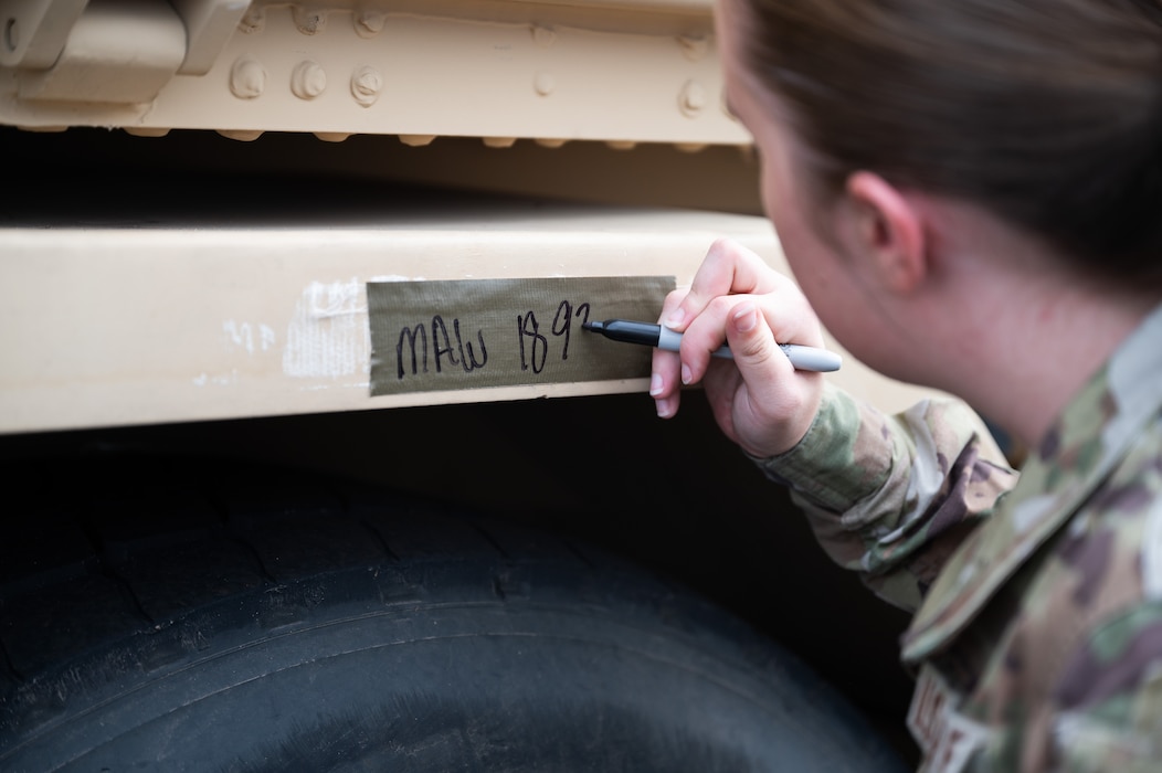 Airman 1st Class Melisa Reynolds, 97th Logistics Readiness Squadron, writes down the weight of a U.S. Army vehicle during a training event at Altus Air Force Base, Okla., Aug. 20, 2025. During the event, 23 Soldiers—most of who were straight out of technical training—were given hands-on experience with loading and unloading their equipment onto a C-17 Globemaster III. (U.S. Air Force photo by Tech. Sgt. Hailey Haux)