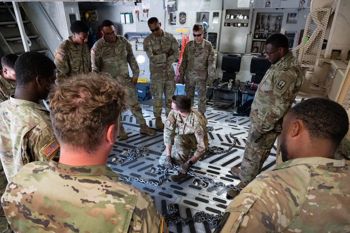 Staff Sgt. Andrew Chatfield (center), 58th Airlift Squadron loadmaster, instructs U.S. Army Soldiers from Alpha Battery, 3-2 Air Defense Artillery, 31st ADA Brigade, 32 Air and Missile Defense Command on how to load their vehicles onto a C-17 Globemaster III aircraft for a training event at Altus Air Force Base, Okla., Aug. 20, 2025. Once each piece of equipment was uploaded and downloaded, the loadmasters talked through any difficulties they may come across in the future as well as how to overcome those challenges—giving them all the tools they would need to be successful in future operations. (U.S. Air Force photo by Tech. Sgt. Hailey Haux)