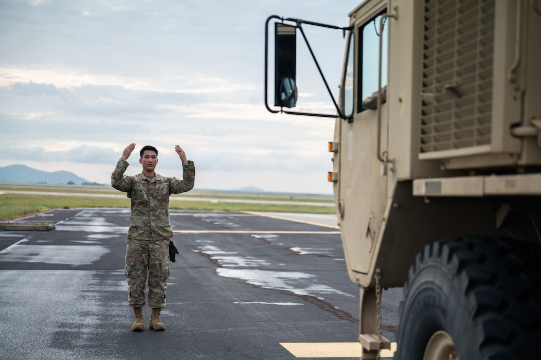 Airman 1st Class Purevdemberel Oyuntsetseg, 97th Logistics Readiness Squadron, marshals a U.S. Army vehicle onto a pair of scales during a training event at Altus Air Force Base, Okla., Aug. 20, 2025. Loadmasters from the 58th Airlift Squadron conducted static load training with the Army’s Alpha Battery, 3-2 Air Defense Artillery, 31st ADA Brigade, 32 Air and Missile Defense Command out of Fort Sill. (U.S. Air Force photo by Tech. Sgt. Hailey Haux)