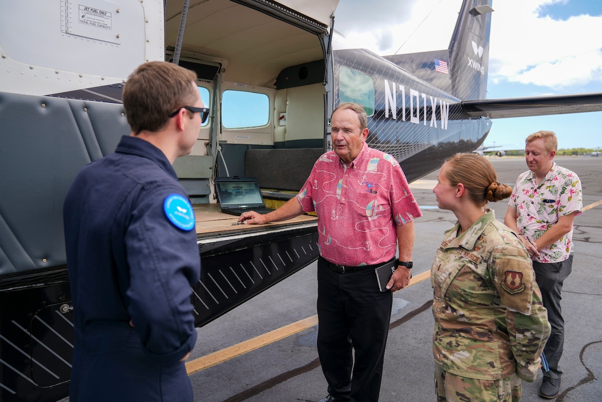 Dr. Bob Stephenson, U.S. Indo-Pacific Command director of requirements and resources (J8), gets briefed by Craig Milliard, Joby flight test lead, and 2nd Lt. Sarah Hubert, AFWERX program manager, on the autonomous capabilities of the Joby Aviation Cessna 208B Grand Caravan during the Department-Level Exercise at Joint Base Pearl Harbor-Hickam, Hawaii, July 28, 2025.