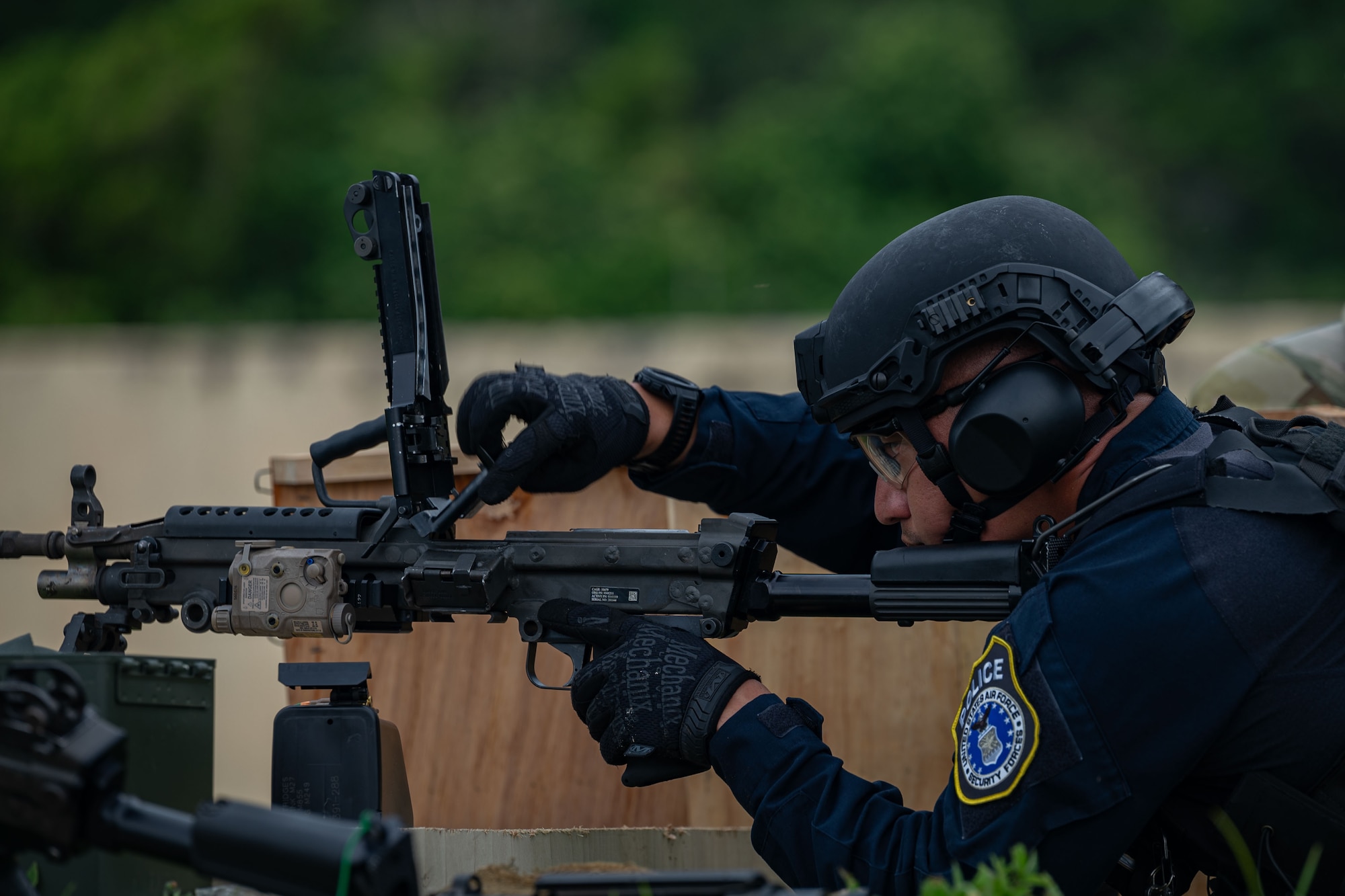 Photo of a police officer reloading an M249 Squad Automatic Weapon