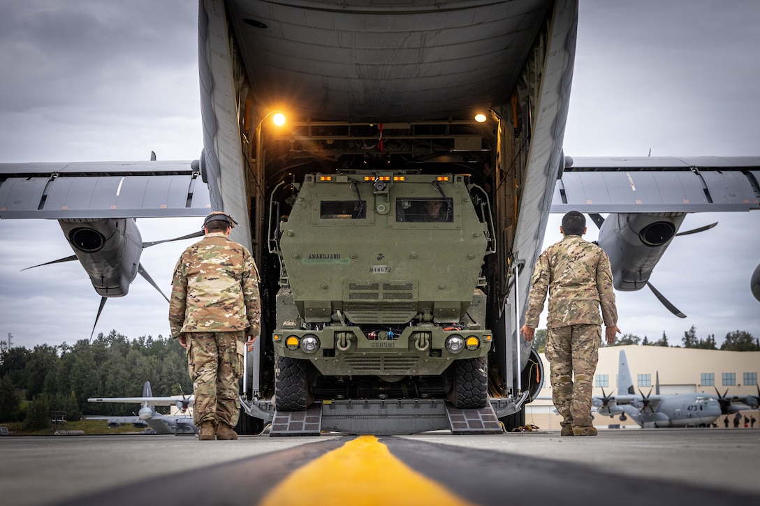 U.S. Airmen assigned to the 27th Special Operations Wing, load a High Mobility Artillery Rocket System (HIMARS) onto a MC-130J Commando II during ARCTIC EDGE 2025 (AE25) at Joint Base Elmendorf-Richardson, Alaska, Aug. 19th, 2025. Specialized Arctic training generates valuable lessons learned for warfighters and enablers ensuring they can execute their assigned missions in any environment. AE25 is a NORAD and U.S. Northern Command-led homeland defense exercise designed to improve readiness, demonstrate capabilities and enhance Joint and Allied Force interoperability in the Arctic. (U.S. Marine Corps Photo by Lance Cpl. Edward Spears)