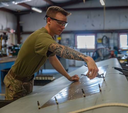920th Maintenance Squadron aircraft structural maintenance technician, removes a skin panel from the right-hand aileron of an HC-130J Combat King II aircraft.