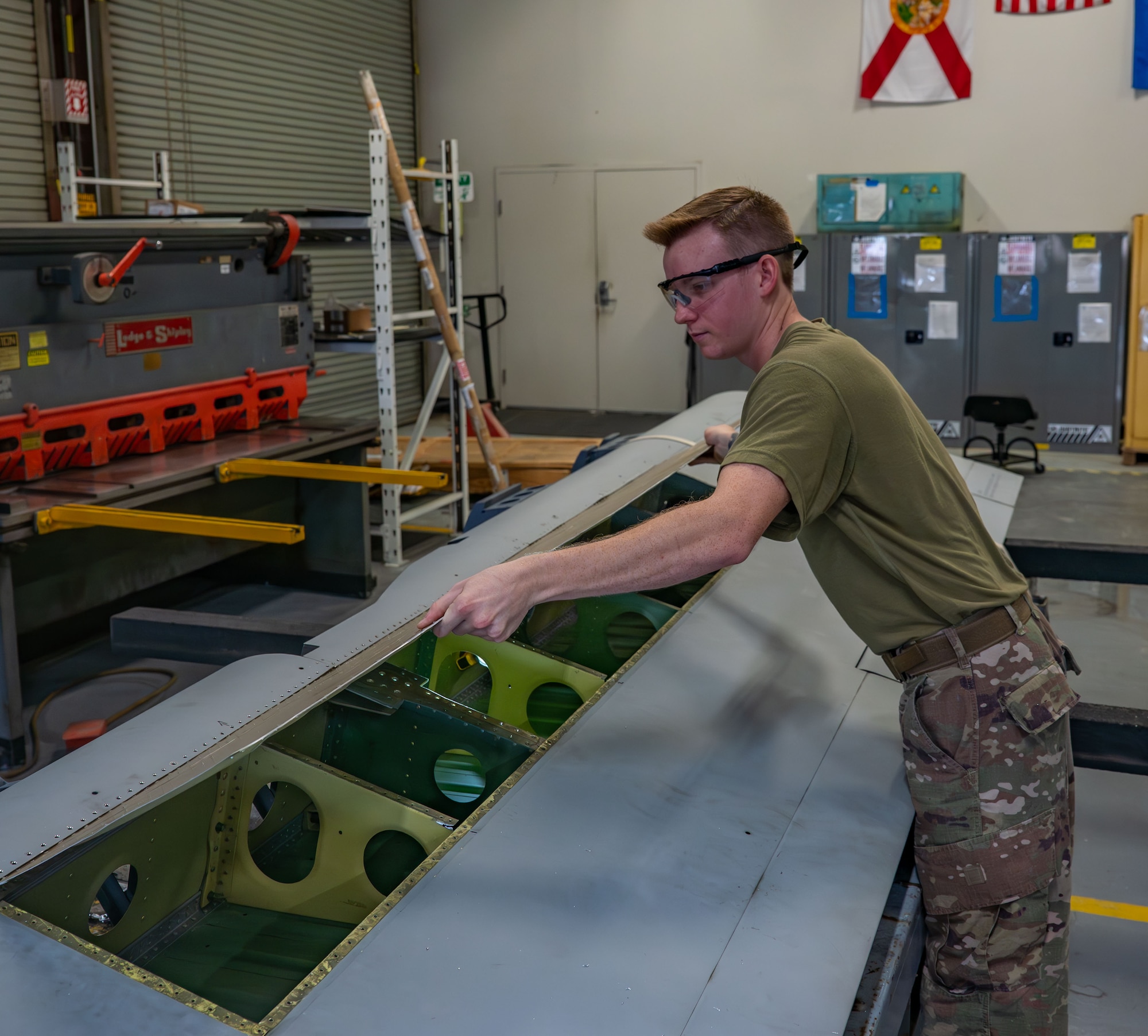 920th Maintenance Squadron aircraft structural maintenance technician, secures a new skin panel on the right-hand aileron of an HC-130J Combat King II aircraft