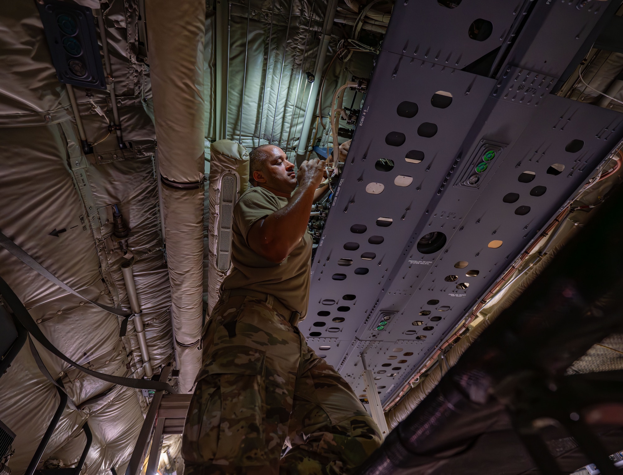 An Airman repairs the satellite communication component of an HC-130J Combat King II aircraft