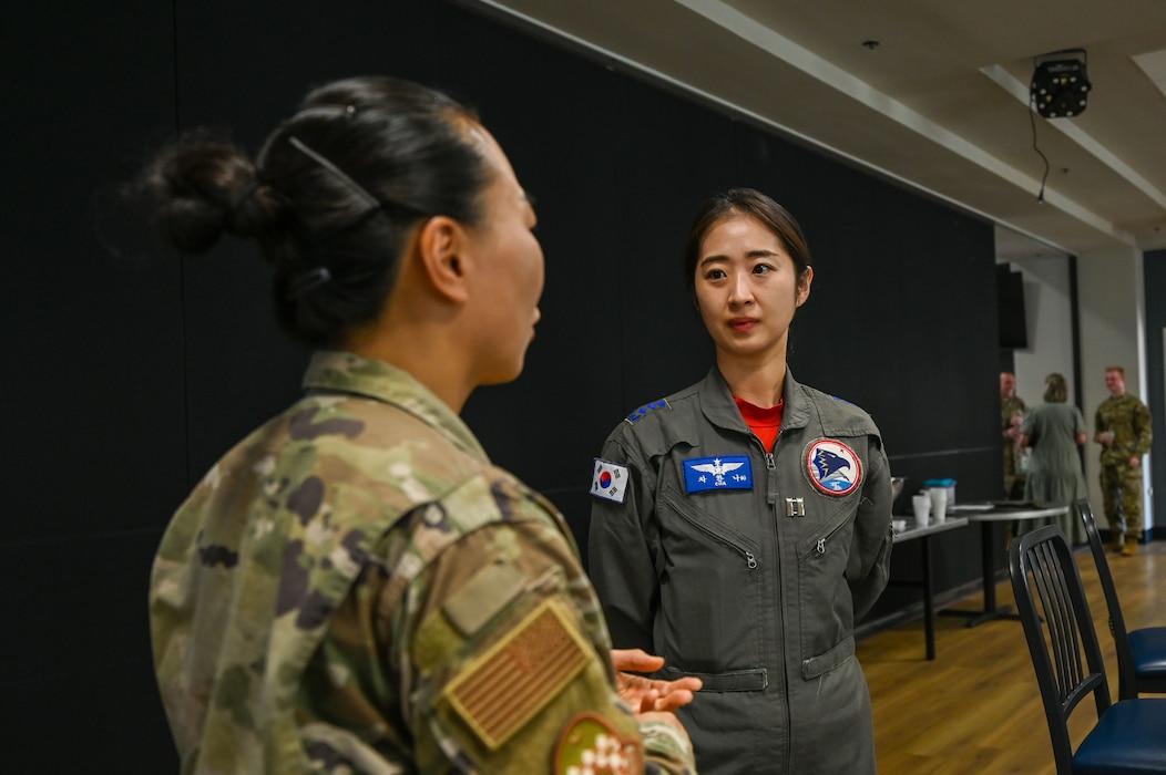 U.S. and Republic of Korea service members engage in conversation during International Exchange Day at the Powell Event Center, Goodfellow Air Force Base, Texas, Aug. 21, 2025. Republic of Korea Air Force Capt. Hannah Cha, International Intelligence Applications Officer Course student, speaks in Korean with U.S. Air Force Capt. Jina Miller, 316th Training Squadron flight commander during the event, which highlighted cross-cultural connections among allied and partner nations. (Airman 1st Class Maria Mota)