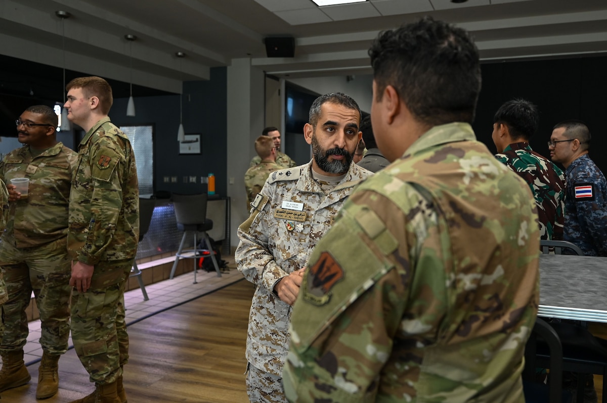U.S. and international service members engage in a conversation during International Exchange Day at the Powell Event Center, Goodfellow Air Force Base, Texas, Aug. 21, 2025. Royal Saudi Air Force Lt. Col. Turki Alshehri, a student in the International Intelligence Applications Officer Course, speaks with a U.S. Air Force member during the event, which fostered connection and cooperation across allied and partner nations. (U.S. Air Force photo by Airman 1st Class Airman 1st Class Maria Mota)
