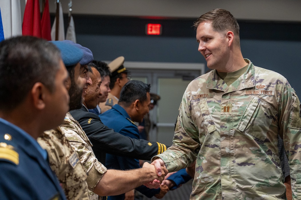U.S. Air Force Capt. Thomas Jewett, 316th Training Squadron flight commander, congratulates international students following their graduation at the Powell Event Center, Goodfellow Air Force Base, Texas, July 18, 2025. The graduates completed the International Intelligence Applications Officer Course, which brought together officers from 10 partner nations to strengthen coalition interoperability and shared intelligence practices. (U.S. Air Force photo by Airman 1st Class James Salellas)