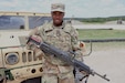 Pfc. Dewitt Dennis, a unit supply specialist assigned to the 650th Regional Support Group, poses for a photo with an M240b machine gun while waiting to fire his assigned weapon at the crew-served weapons range at Fort Hood, Texas on July 27, 2025.