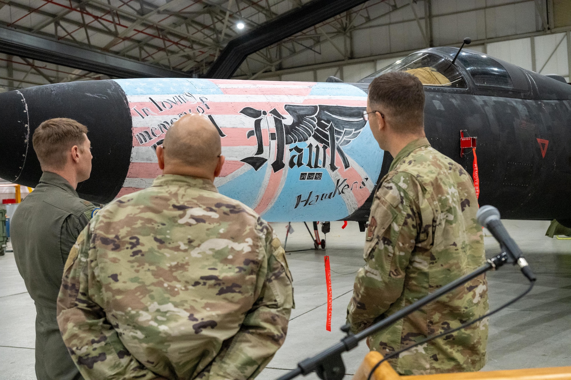 Airmen observe memorial nose art painted on a U-2 Dragon Lady