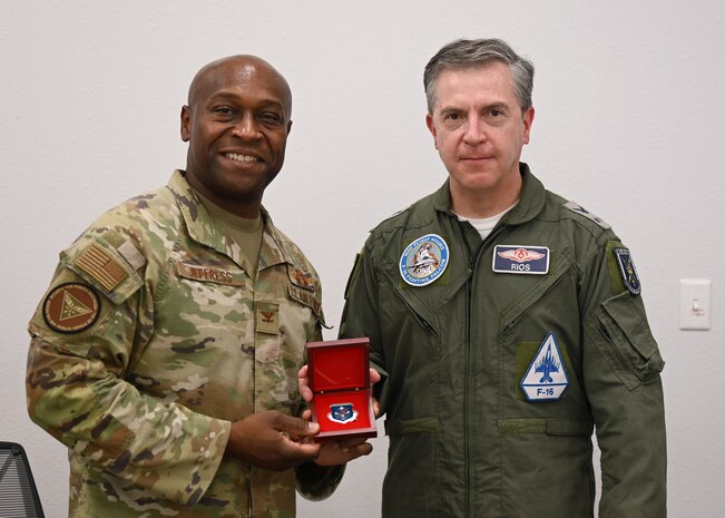 U.S. Air Force Col. Henry Jeffress, Air Forces Southern deputy commander, left, presents Chilean (FACh) Air Force Maj. Gen. Alfredo Ríos, FACh director of operations, right, a coin during the annual Airman-to-Airman Talks at Davis-Monthan Air Force Base, Arizona, Aug. 28, 2025. Jeffress and Ríos came to an agreement for mutual military growth and strengthened their U.S.-Chilean partnership. (U.S. Air Force photo by Staff Sgt. Abbey Rieves)