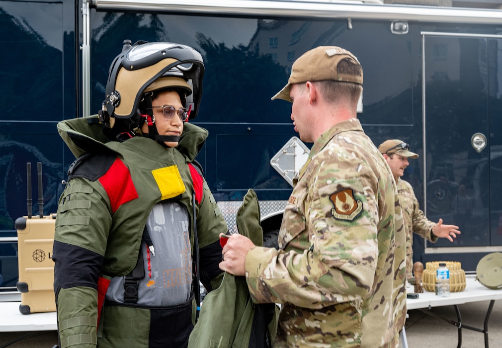 An attendee at the Dayton Dragons American Celebration Night tries on the Explosive Ordinance Disposal Bomb suit during the pregame activities outside Dayton Air Ballpark, Aug. 23, 2025. In addition to throwing out the pitch, 30 individuals took the oath of enlistment to delayed enlistment personnel during the game. (U.S. Air Force photo by Jack Gardner)