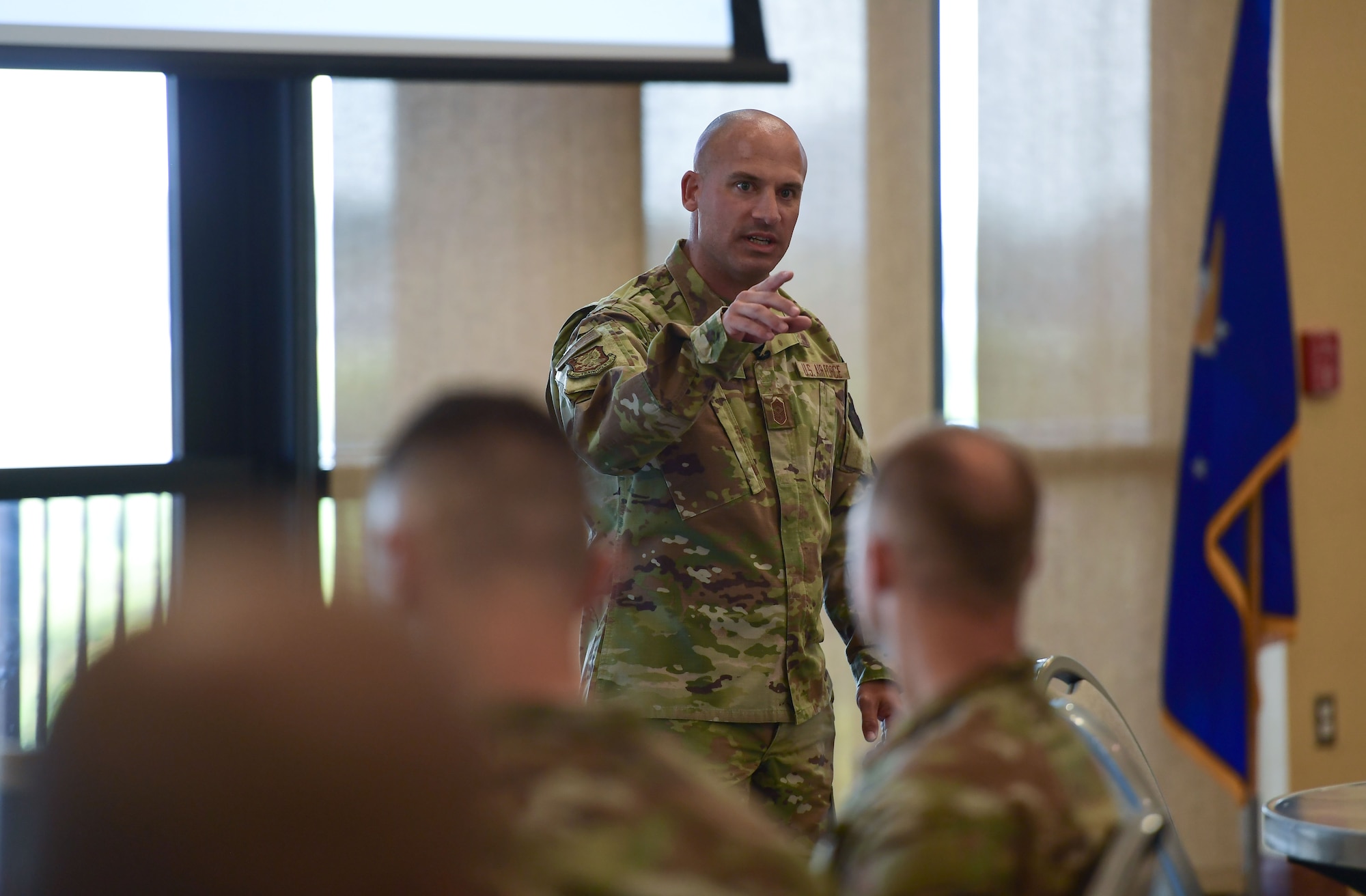 A man in military uniform speaks to a crowd of people