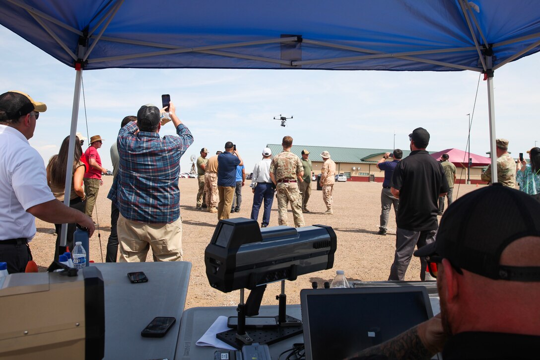 Crowd watches drone fly.