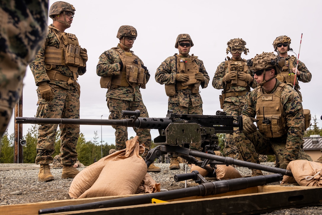 U.S. Marine Corps Cpl. Elliott Russell, a machine gunner, with 3rd Battalion, 4th Marine Regiment, 1st Marine Division, goes over proper firing procedures of a .50 caliber machine gun during a range familiarization training as part of ARCTIC EDGE 2025 (AE25), at Joint Base Elmendorf-Richardson, Alaska, Aug. 16th, 2025. Specialized Arctic training generates valuable lessons learned for warfighters and enablers ensuring they can execute their assigned missions in any environment. AE25 is a NORAD and U.S. Northern Command-led homeland defense exercise designed to improve readiness, demonstrate capabilities and enhance Joint and Allied Force interoperability in the Arctic. (U.S. Marine Corps Photo by Lance Cpl. Edward Spears)