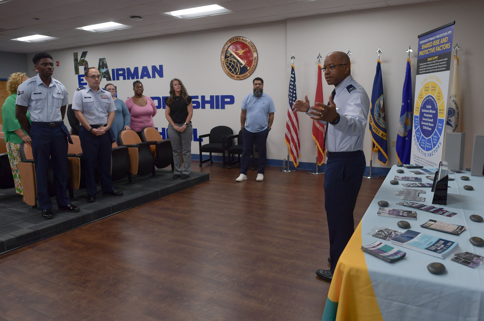 A man in military uniform speaks to a group of people.