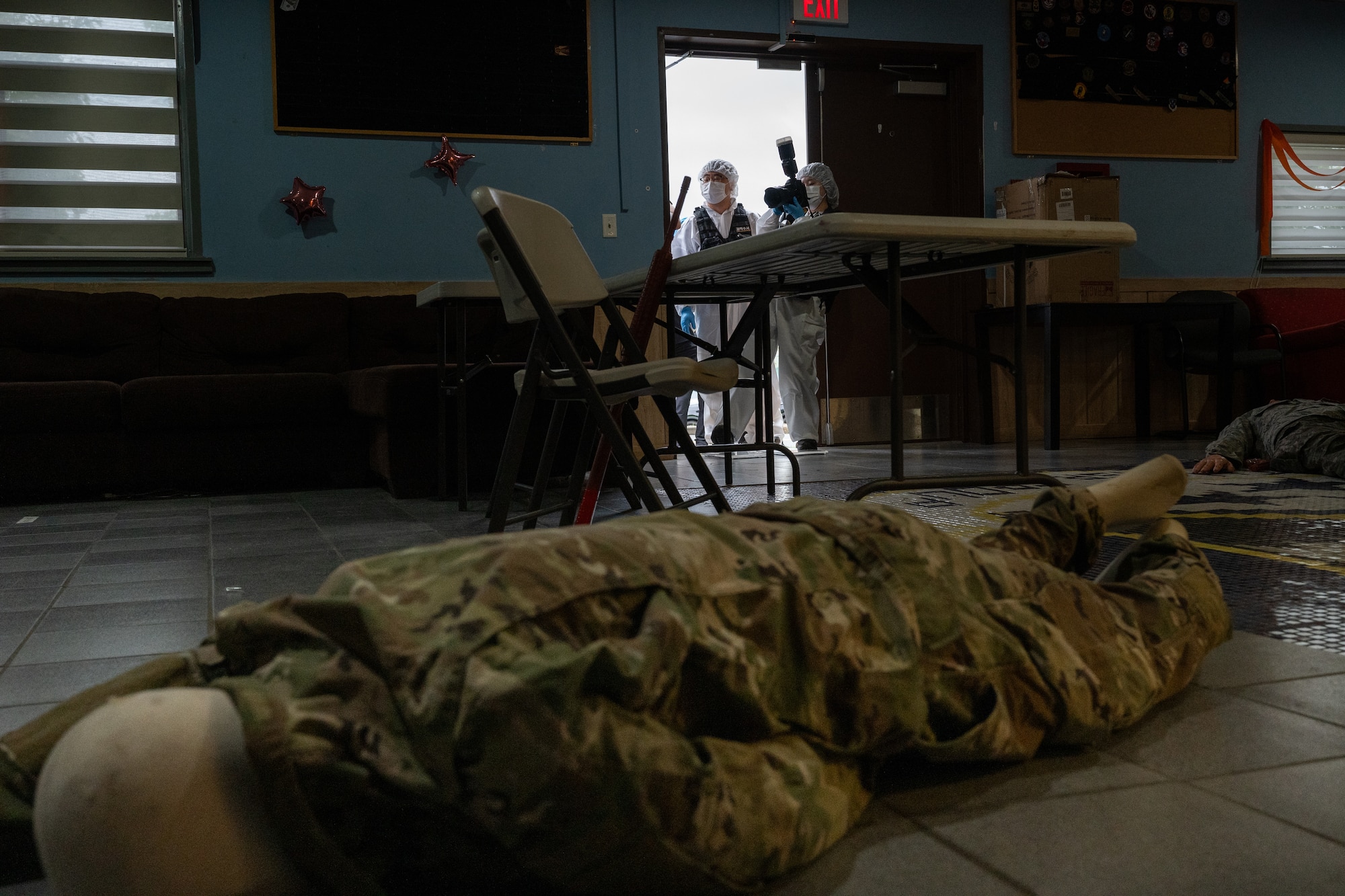 Crime scene investigators photograph a simulated crime scene during a training scenario.